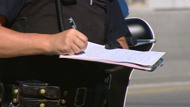 Police Officer Writing a Highway Traffic Act Violation Certificate